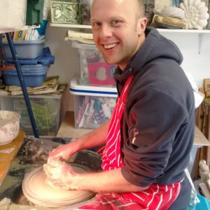 man sitting at a potters wheel for a private pottery lesson with Northern Irish artist McCall Gilfillan