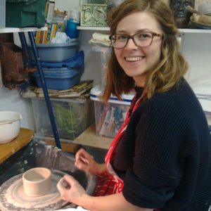 student creating a pot on a potters wheel with Northern Irish artist McCall Gilfillan